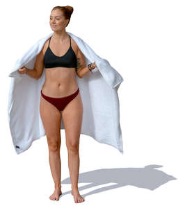 woman in a bathing suit standing and holding a towel