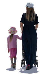 backlit mother and daughter walking