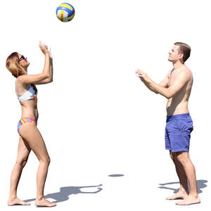 man and woman playing volleyball on the beach