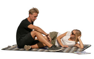 man and woman sitting on a picnic blanket and talking