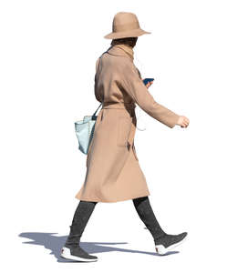 woman in a brown overcoat and hat walking