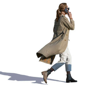woman in a trenchcoat walking hastily
