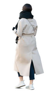 woman in a white overcoat walking