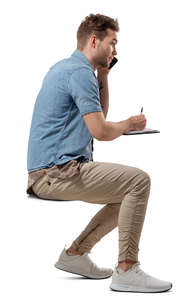 man sitting at a table and writing
