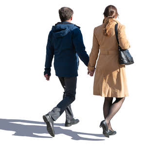backlit man and woman walking hand in hand
