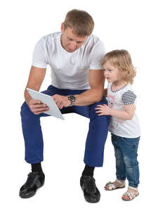 father sitting and looking at tablet with his daughter