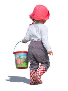 little girl with a toy bucket walking