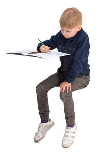 boy sitting behind the desk and drawing