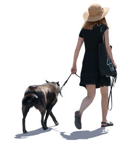 backlit woman walking a dog