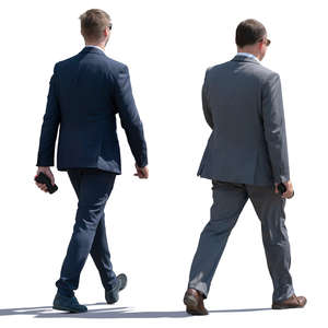 two backlit businessmen walking