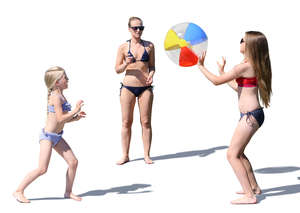 mother with two daughters playing ball at the beach