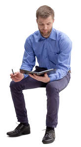 man in an office sitting and taking notes