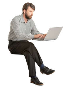 man sitting and working on a laptop