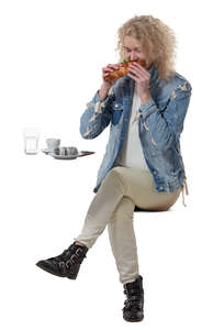 woman sittng in a cafe and eating a sandwich