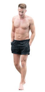 man in swimming shorts walking