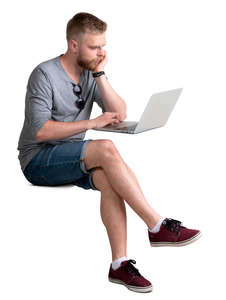 man with a laptop sitting behind the desk