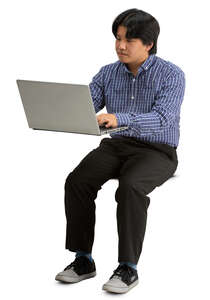 asian man sittinf behind a desk with laptop