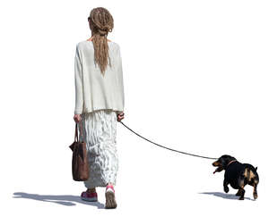 woman in a long white dress walking a dog