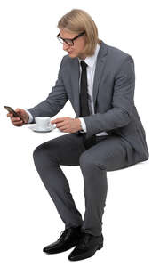 man in a suit drinking coffee in a cafe