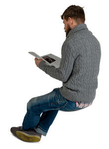 man sitting and reading a magazine