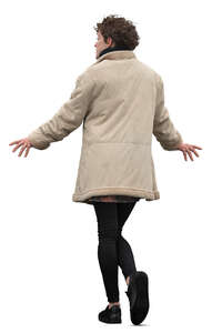woman in a beige overcoat leaning on a railing
