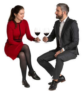 man and woman sitting in a restaurant and drinking wine
