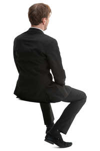 man in a black suit sitting