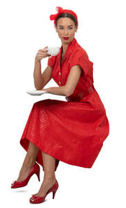 woman in a vintage red dress sitting and drinking coffee