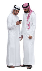 two emirati men standing and looking at a phone