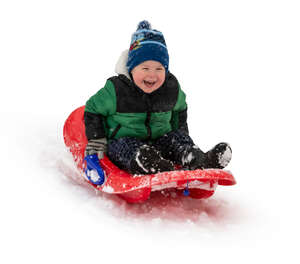 happy little boy sledging down the hill