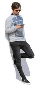 man leaning against the wall and texting