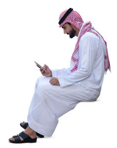 arab man in traditional clothing sitting and texting
