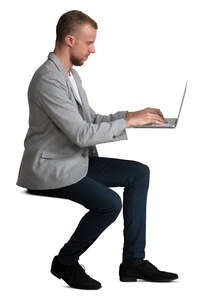 man sitting and working with laptop at the desk