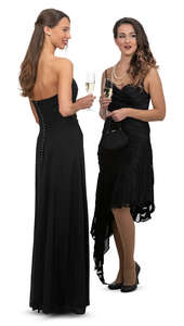 two women in black evening dresses at a formal event standing and talking