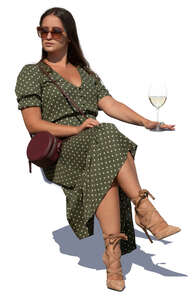 woman sitting in an outdoor cafe and drinking white wine