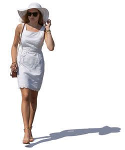 woman in a white summer dress and hat walking