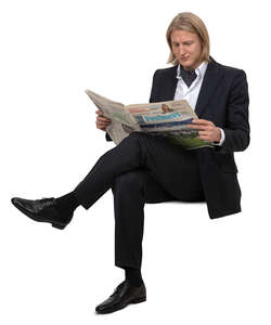 man in a suit sitting and reading a newspaper