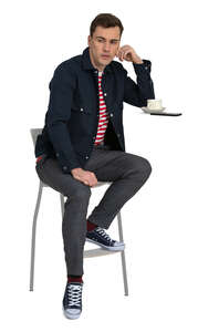 young man sittin in a coffee bar and drinking coffee