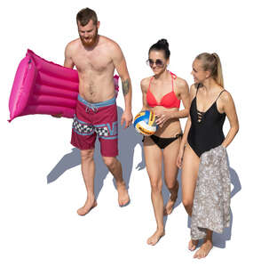 group of three young people walking at the beach seen from above