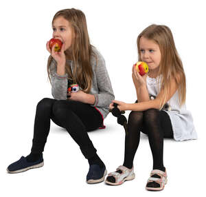 two girls sitting and eating apples