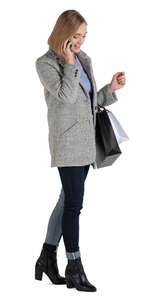 woman with shopping bags standing and talking on a phone