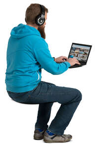 man with headphones sitting at the desk and working