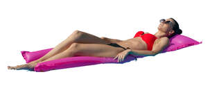 woman sunbathing on a swim mattress in the pool