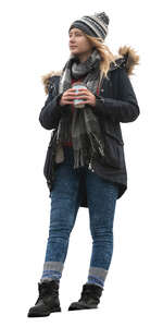 woman in a winter coat standing on a balcony and drinking coffee