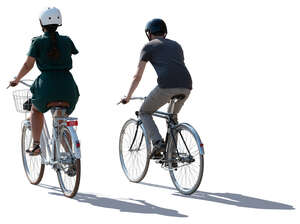 backlit man and woman cycling side by side