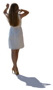 backlit woman in a white dress standing