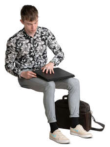 young man sitting and opening his laptop