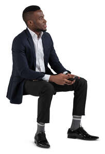 black man in a suit sitting on a chair