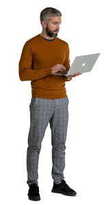 man standing and holding a laptop 