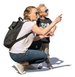 woman squatting and showing something to her son